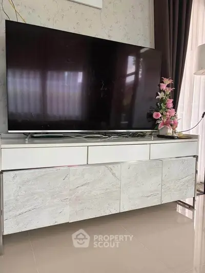 Modern living room with sleek TV stand and large flat-screen TV, perfect for entertainment.