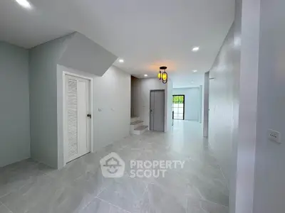Spacious modern interior with sleek tile flooring and elegant lighting, perfect for contemporary living.