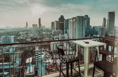 Stunning cityscape view from a high-rise balcony with modern seating, perfect for urban living enthusiasts.