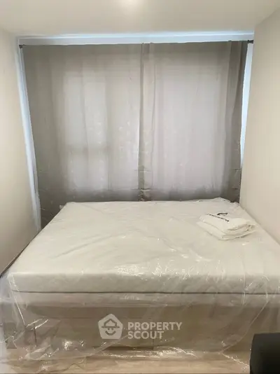 Cozy bedroom with large bed and soft curtains, perfect for restful nights.