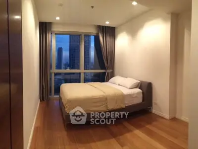 Spacious bedroom with city view, featuring a cozy bed and elegant wooden flooring.