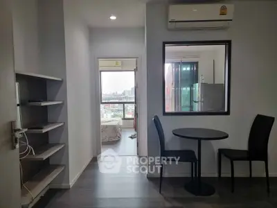 Modern apartment interior with dining area and view into bedroom, featuring sleek furniture and cityscape view.