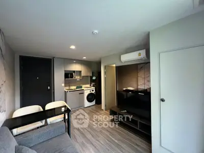 Modern living room with open kitchen and sleek appliances in a stylish apartment.