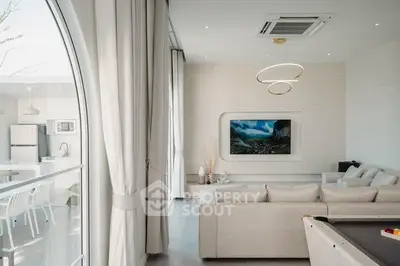 Luxurious modern living room with elegant decor and open kitchen layout.
