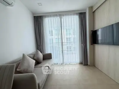 Modern living room with sleek design, featuring a wall-mounted TV and elegant curtains.