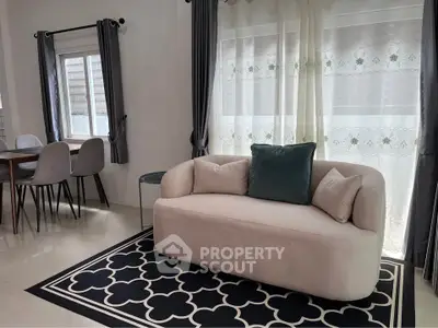 Modern living room with stylish sofa and dining area, featuring elegant curtains and chic decor.