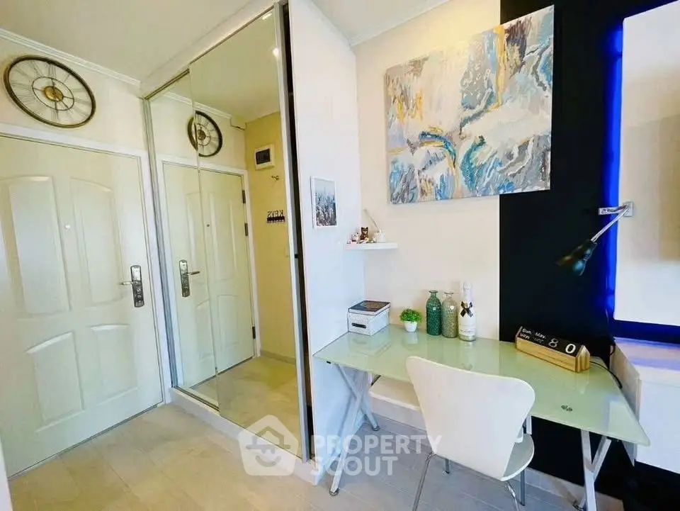 Modern study area with glass desk and stylish decor in a contemporary apartment.