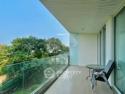 Spacious balcony with glass railing and scenic views, perfect for relaxation and outdoor dining.