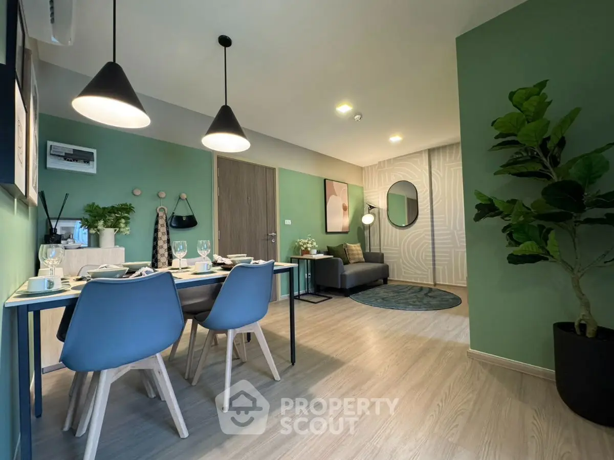 Modern living room with dining area, stylish decor, and green accent walls.