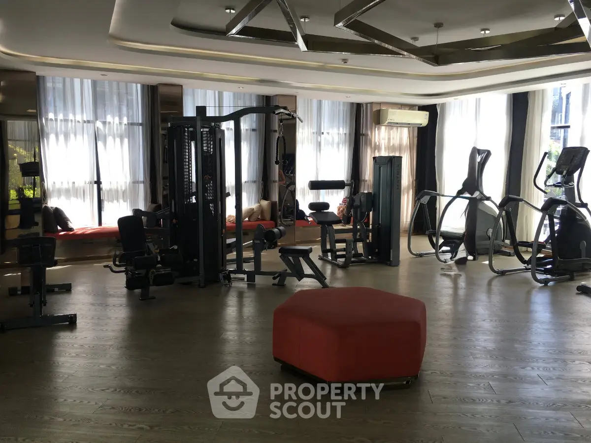 Luxurious gym with modern fitness equipment and stylish interior design in upscale residential building.