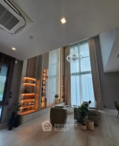 Luxurious modern living room with high ceilings and elegant chandelier