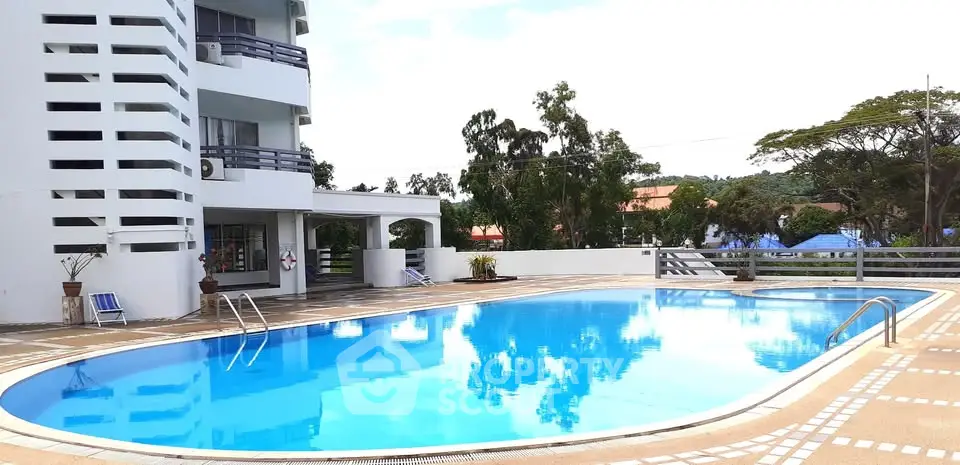 Luxurious apartment complex with a stunning outdoor pool and modern architecture.