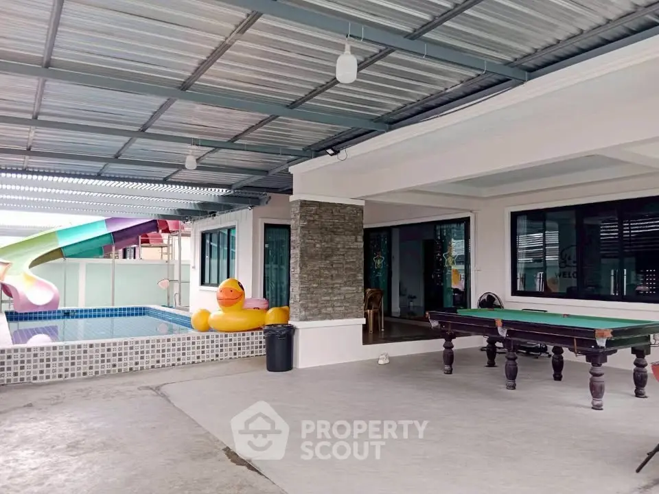 Spacious covered patio with pool and slide, perfect for entertaining.