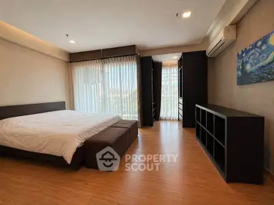 Spacious bedroom with large windows and modern decor