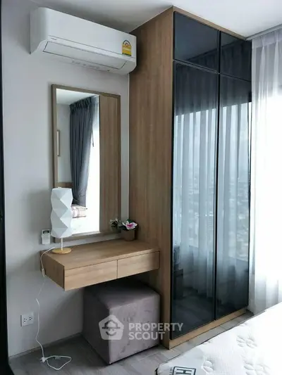 Modern bedroom with sleek wardrobe and vanity, featuring a stylish air conditioner.
