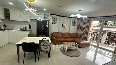 Modern open-plan living room with sleek kitchen and spacious balcony access.