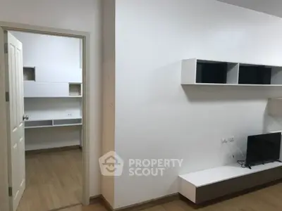 Modern minimalist living room with wall-mounted TV and open shelving
