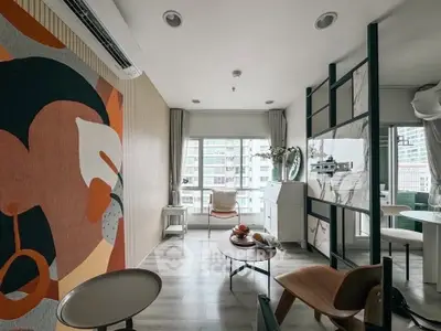 Modern living room with stylish decor and city view, featuring contemporary furniture and large windows.