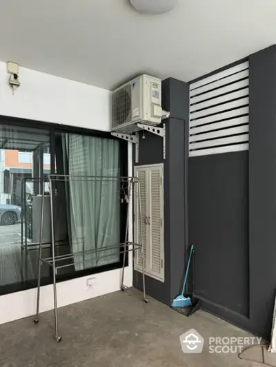 Modern balcony with air conditioning unit and clothes drying rack