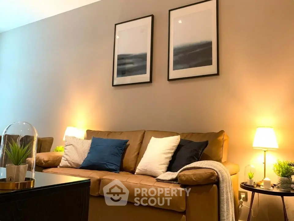 Cozy living room with stylish decor and warm lighting, featuring a comfortable leather sofa and modern artwork.