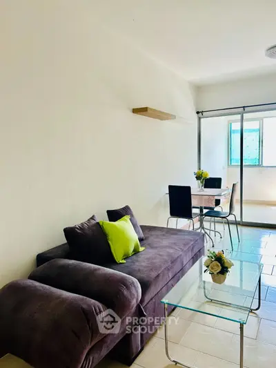 Bright living room with modern sofa and dining area, perfect for cozy gatherings.