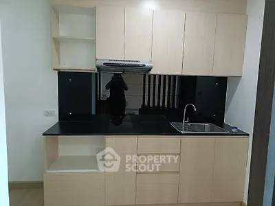 Modern kitchen with sleek black countertops and light wood cabinets