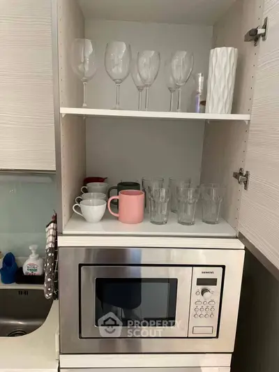 Modern kitchen with built-in microwave and glassware display