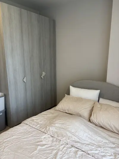 Cozy bedroom with modern wardrobe and plush bedding, perfect for relaxation.