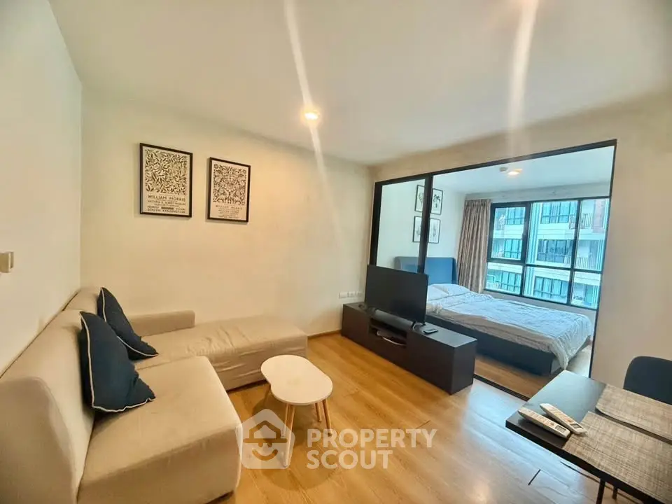 Modern living room with cozy sofa and bedroom view in stylish apartment