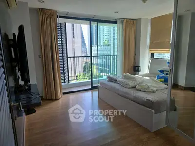 Modern bedroom with city view and balcony access in high-rise apartment