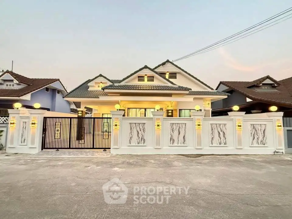 Charming single-story house with elegant facade and gated entrance at sunset.