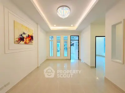 Spacious modern living room with elegant chandelier and artistic wall decor