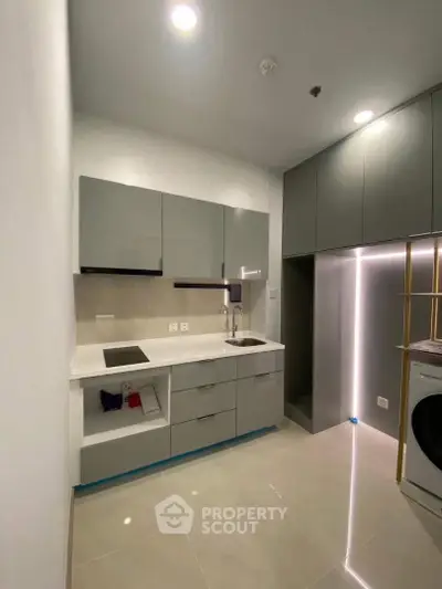 Modern kitchen with sleek cabinetry and integrated appliances in a compact layout.