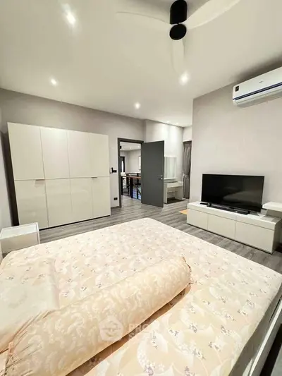 Spacious modern bedroom with elegant decor and ample natural light