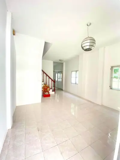 Spacious and bright living room with modern lighting and tiled flooring, perfect for family gatherings.