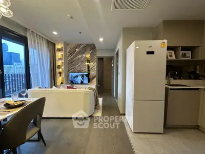 Modern open-plan living room with city view, stylish decor, and sleek kitchen area.
