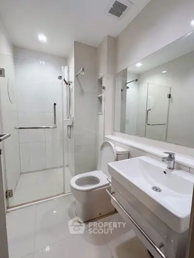 Modern bathroom with glass shower and sleek fixtures in a contemporary home.
