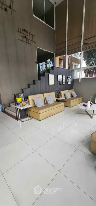 Spacious modern living room with high ceilings and stylish decor, perfect for entertaining guests.