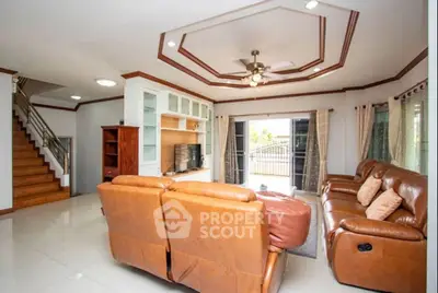 Spacious living room with leather sofas and elegant ceiling design