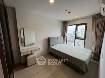 Modern bedroom with city view, featuring sleek furniture and large window for natural light.