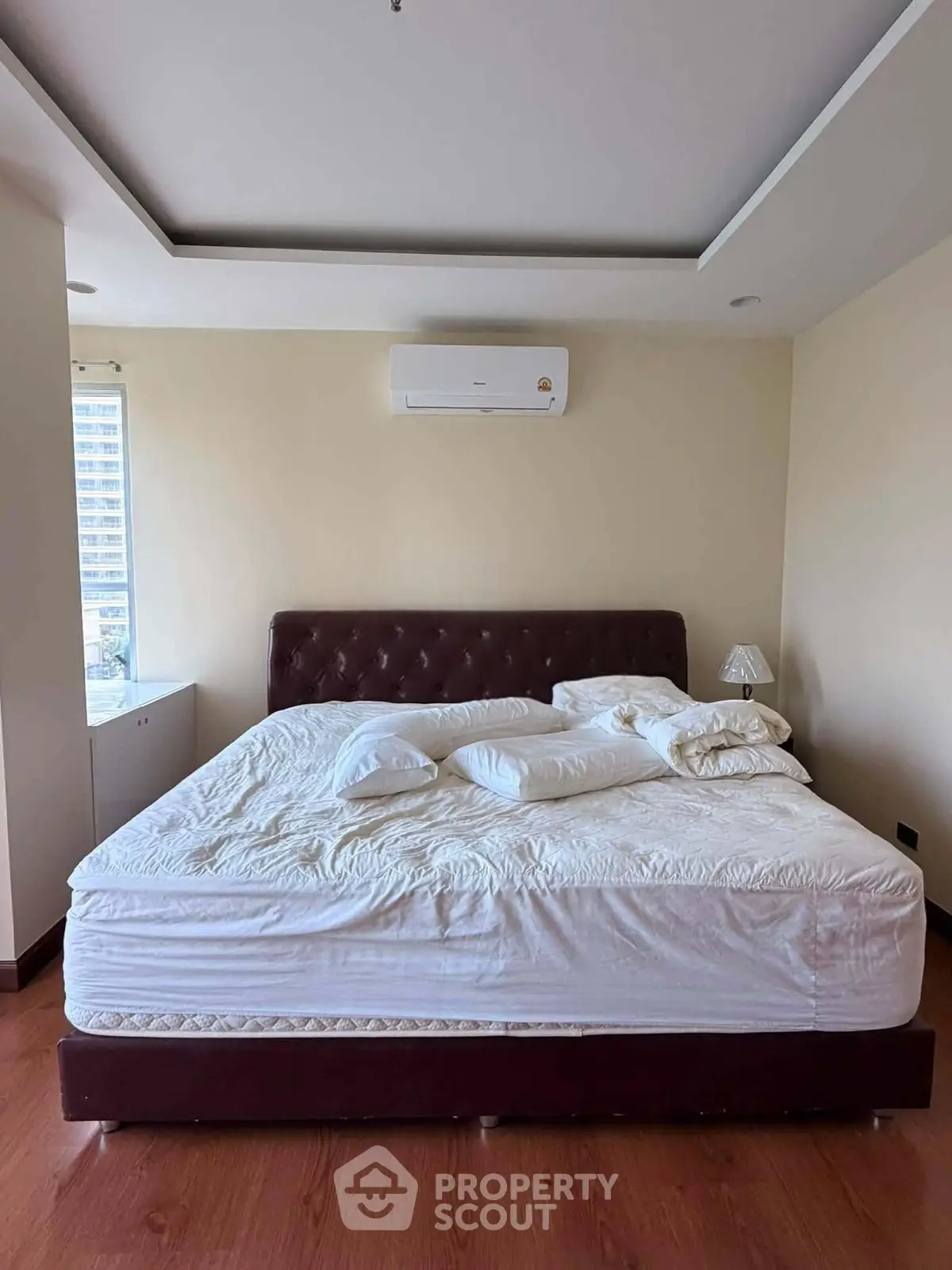 Spacious bedroom with large bed and modern air conditioning unit, perfect for comfort and relaxation.