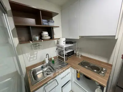Compact kitchen with modern appliances and wooden countertops in cozy apartment.