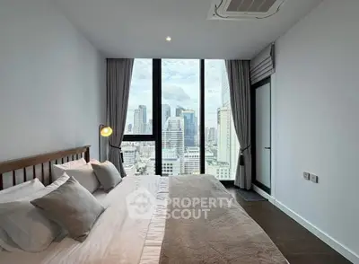 Luxurious bedroom with stunning city view and modern decor in high-rise apartment.