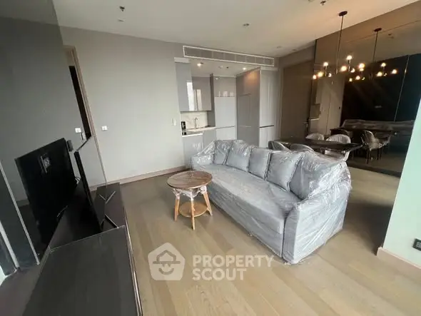 Modern living room with sleek furniture and open kitchen layout in a stylish apartment.