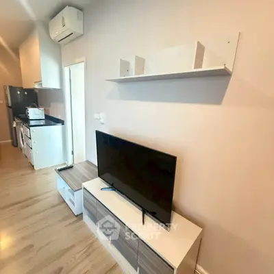 Modern living room with sleek TV setup and stylish kitchen appliances