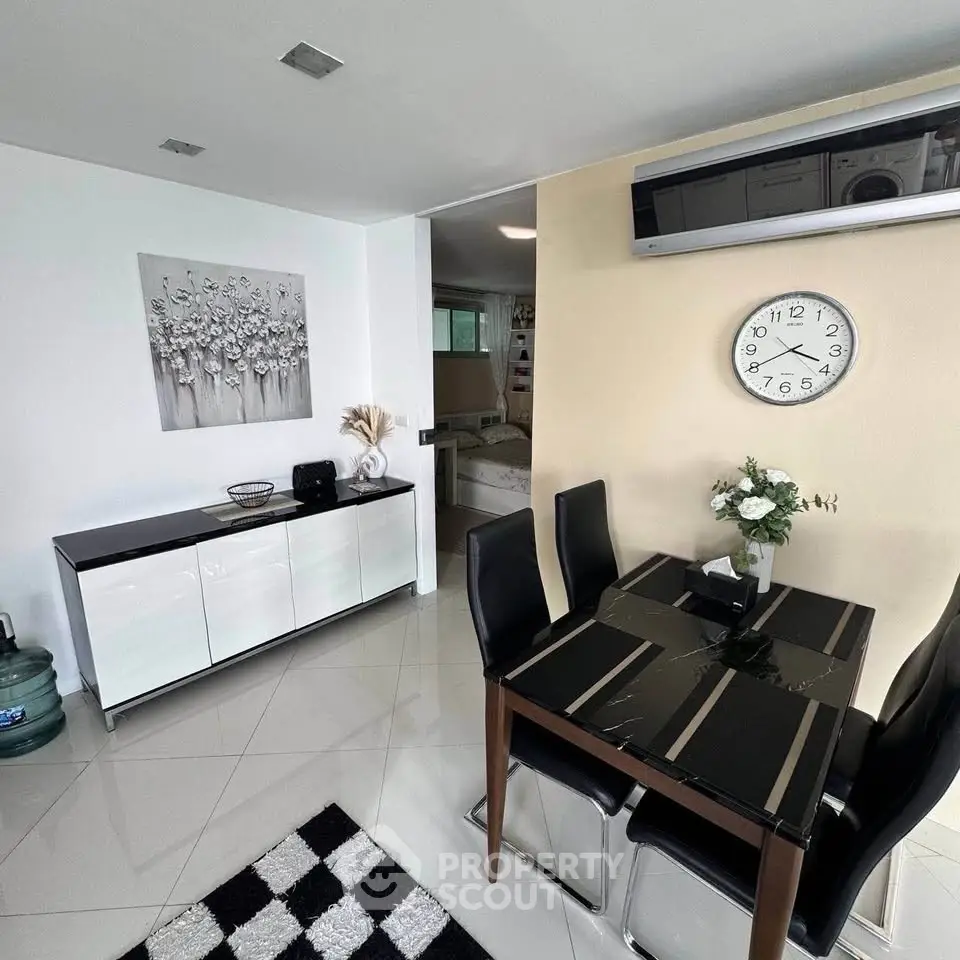 Modern dining area with sleek black chairs, stylish decor, and wall-mounted air conditioning unit.