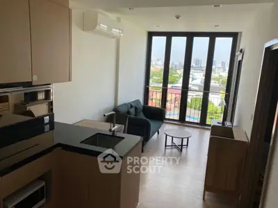 Modern living room with city view, featuring sleek furniture and large windows for natural light.