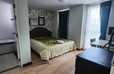 Cozy bedroom with stylish decor and natural light, featuring a comfortable bed and work desk.