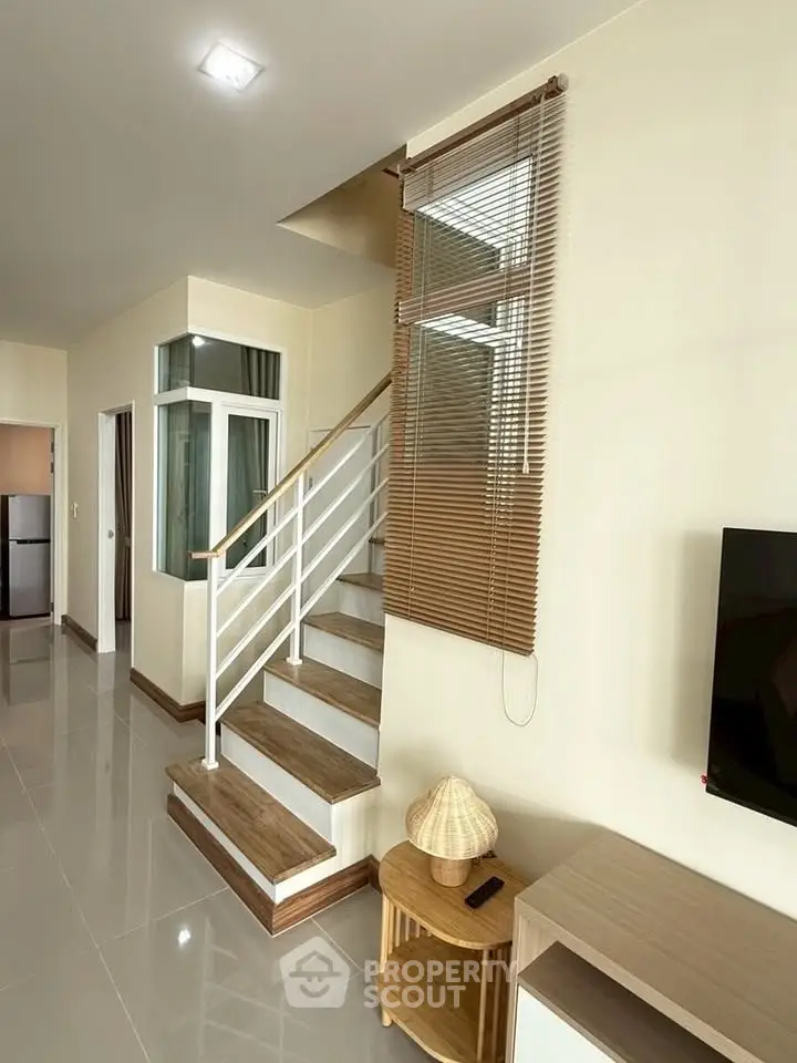 Modern interior with staircase and sleek design, featuring a cozy living area and stylish decor.