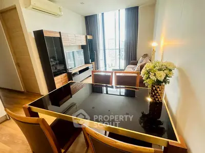 Modern living room with elegant dining area and large windows offering city views.